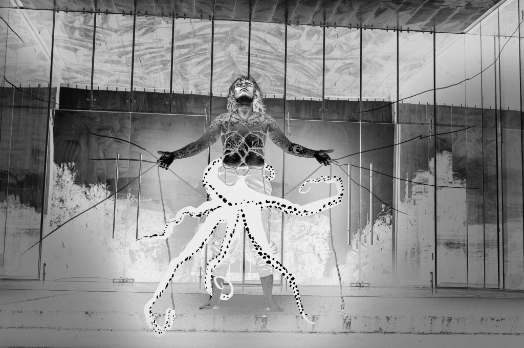 Octopus arms stretch from the humanoid figure's crotch. They spread their own arms wide, head tilted towards the sky.